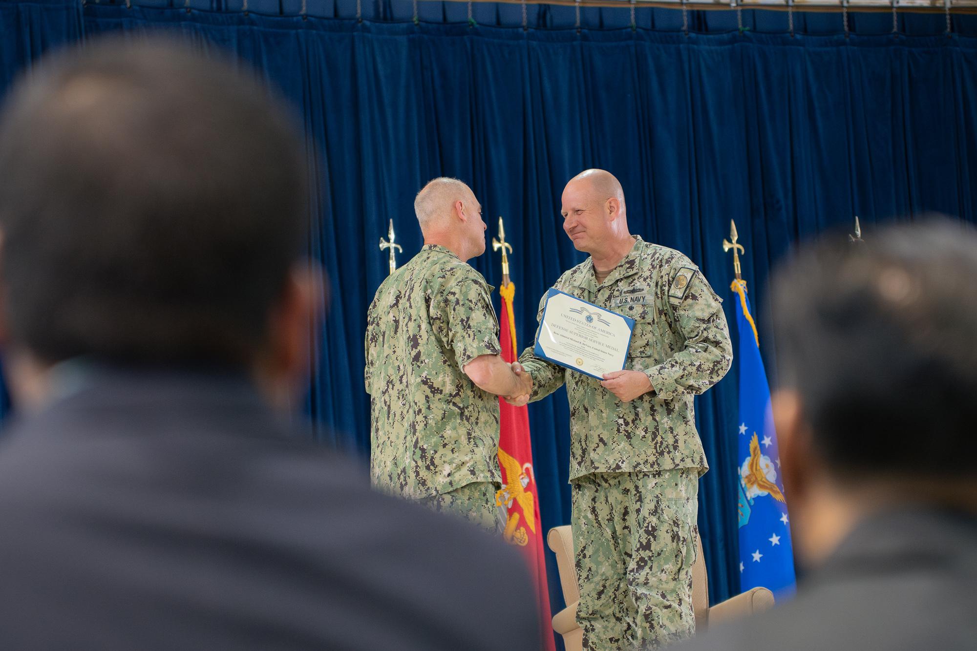 Presiding officer, Rear Adm. Scott Gray presents Devore with the Defense Superior Service Medal. Photo by Skyler Obispo 
