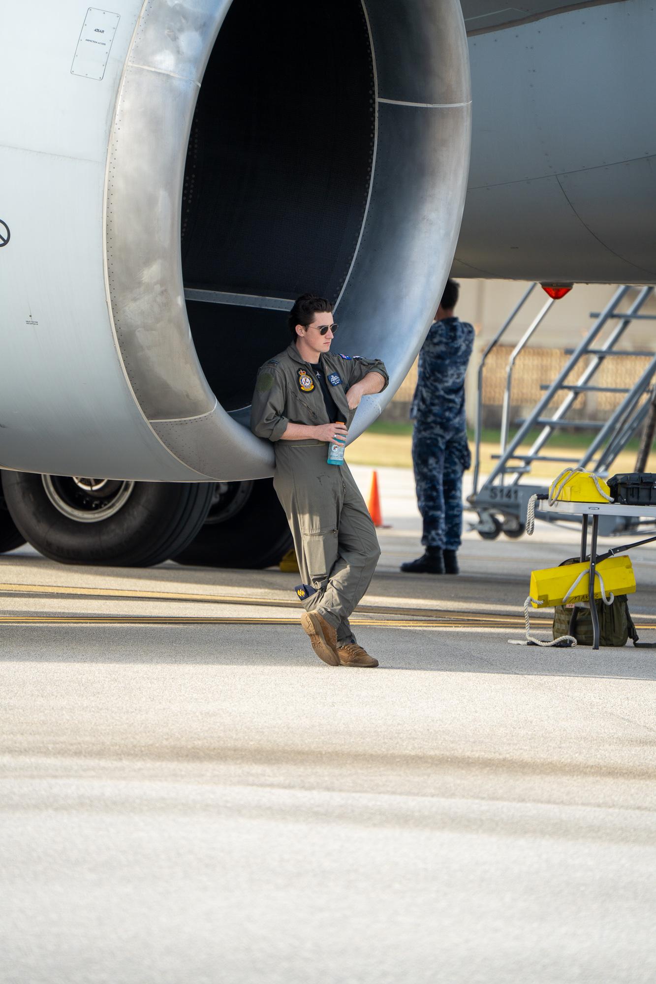 Royal Australian Air Force FLGOFF Connor Donnelly resting near the engine of a RAAF KC-30A Multi-Role Tanker Transport. Photo by Skyler Obispo. 