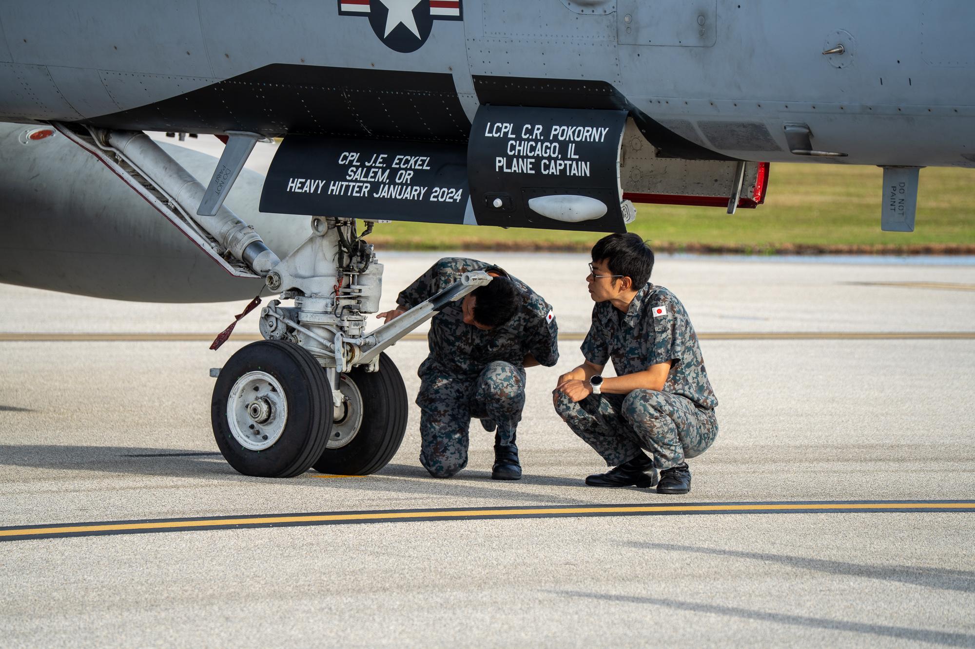 Two JASDF airman inspect the underside of a Marine Corp. F/A-18C Hornet that&#039;s attached to Marine Fighter Attack Squadron 312. Photo by Skyler Obispo. 