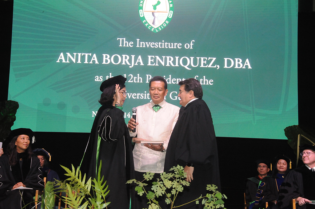 Anita Borja Enriquez was sworn in by Chief Justice Robert J. Torres at right. Her husband, Noel M. Enriquez, senior program manager, McDonald-Bedford LLC; stands between them. Noel Enriquez also presented his wife with the University Collar. 